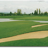 Hole #15 is a slight dogleg left par 4. The photo was taken from a group of mounds that contain three fairway bunkers. If you can avoid these and the rough just behind them, make sure you select the proper club for your approach shot. Water surrounds the 