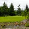 Hole #1 is a par 5 that starts with a downhill tee shot that doglegs right about 220 yards out. A creek cuts across the fairway just in front of the green. The photo was taken from a hillside to the back of the green leading up to the second hole green.