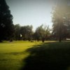 A sunny view of a green at Meadowlawn Golf Club
